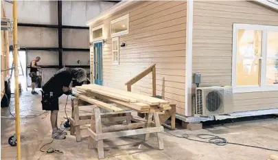  ?? KYLE ARNOLD/ORLANDO SENTINEL ?? A worker at Cornerston­e Tiny Homes in Longwood works on a new foundation model.