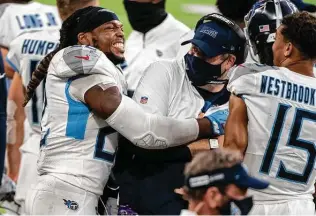  ?? Stephen Maturen / Getty Images ?? Titans offensive coordinato­r Arthur Smith, being hugged by running back Derrick Henry, has turned heads in the NFL with the job he has done in Tennessee.