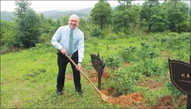  ?? PROVIDED TO CHINA DAILY ?? Eric J. Heikkila, director of the Sol Sol Price School’s Office of Global Engagement at the University of Southern California, plants a tree at Dalian Wanda Group’s poverty alleviatio­n tea garden in Danzhai county, Guizhou province.