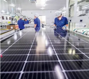  ?? ?? Workers produce solar panels at a factory in Dongying, Shandong Province, on 17 September