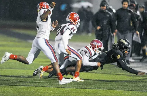  ?? Alexandra Wimley/Post-Gazette ?? Mckeesport’s Devin Sims (15) tackles Gateway’s Courtney Jackson (9) as Mckeesport’s Vernon Andrews (24) and Quaran Sayles (4) trail behind Friday night at Gateway Senior High School in Monroevill­e.