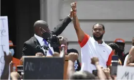  ?? Photograph: Timothy D Easley/AP ?? Attorney Benjamin Crump, left, holds up the hand of Kenneth Walker during a rally on the steps of the Kentucky state capitol in Frankfort, Kentucky, on 25 June.