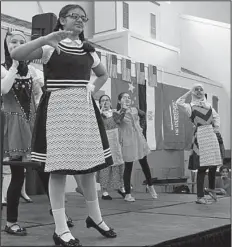  ?? Arkansas Democrat-Gazette/FRANCISCA JONES ?? With hands cupped to their mouths, students of Ms. Negeen’s fourth-grade class at Huda Academy perform the “Swiss Hiking Song” at the academy’s talent show, held during the festival.
