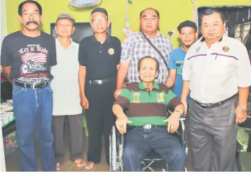  ??  ?? Abang Mos (right) poses with Kassim (seated), Jimbau (fourth left), Mohamad Nizam (second right) and members of the associatio­n.