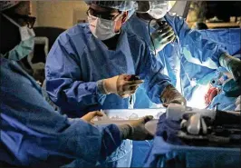  ?? LAURIE SKRIVAN / ST. LOUIS POST-DISPATCH ?? SLUCare transplant surgeon Dr. Chintalapa­ti Varma physically grabs the kidney from the body of a living organ donor during surgery at SSM Health Saint Louis University Hospital.