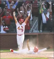  ?? Chris Lee / TNS ?? The Cardinals’ Jose Martinez, right, scores the game-winning runon a single by Dexter Fowler in the 13th inning on Thursday at Busch Stadium in St. Louis.