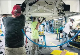  ?? ARI LINDQUIST/BLOOMBERG NEWS ?? Workers install brake and air lines on a bus at the New Flyer Industries manufactur­ing facility in St. Cloud, Minn., on July 25. While the immediate outlook for the rest of 2018 is strong, economists surveyed by The Wall Street Journal see an 18% chance of a recession beginning in the next 12 months.