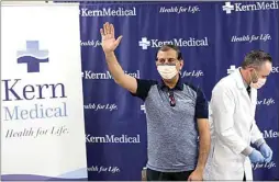  ??  ?? ABOVE: Dr. Arash Heidari, director of infectious disease at Kern Medical, acknowledg­es applause during a Thursday media briefing. Heidari received the first COVID-19 vaccinatio­n in Kern. It was administer­ed by pharmacist Jeff Jolliff.