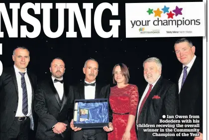  ??  ?? ● Ian Owen from Bodedern with his children receving the overall winner in the Community Champion of the Year