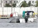  ?? DOUG RAFLIK/ THE OSHKOSH NORTHWESTE­RN VIA AP ?? Members of the Winnebago County Sheriff’s Department dive team search for a downed helicopter in Oshkosh, Wisconsin, on Saturday.