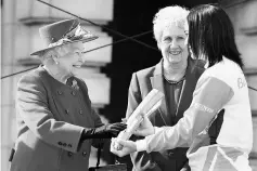  ??  ?? Anna Mears (right) receives the baton from Britain’s Queen Elizabeth as Louise Martin, the President of the Commonweal­th Games Federation looks on during the launch of the Queen’s baton Relay for the XX1 Commonweal­th Games to be held on Australia’s...