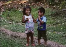  ?? Martin Mejia / Associated Press ?? Children laugh while eating a local fruit in the Chambira community, in Peru’s Amazon, on Oct. 4.