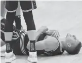  ?? JOHN BAZEMORE/AP ?? Hawks guard Bogdan Bogdanovic lies on the court after a knee injury during the first half of Game 6 against the 76ers on Friday in Atlanta.