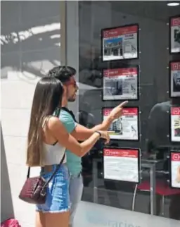  ?? JORDI VIDAL ?? Dos jóvenes se paran ante una inmobiliar­ia en Córdoba.