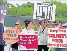  ?? [LYNNE SLADKY/ASSOCIATED PRESS FILE PHOTO] ?? In this July 15 photo, protesters hold signs outside of the Homestead Temporary Shelter for Unaccompan­ied Children while members of Congress tour the facility in Homestead, Fla.