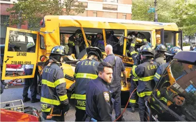  ?? James Keivom / New York Daily News ?? Responders and New York police are on the scene where a driver ended his deadly pickup truck rampage by ramming into a school bus after mowing down bicyclists and pedestrian­s on a bike path along the Hudson River.