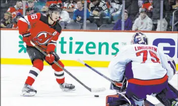  ?? The Associated Press Adam Hunger ?? Devils center Jack Hughes lines up a shot against Capitals goalie Charlie Lindgren during the second period of New Jersey’s 5-1 win Saturday at Prudential Center.