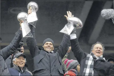  ?? ELISE AMENDOLA / AP ?? Patriots quarterbac­k Tom Brady (center) and coach Bill Belichick (right) hold up Lombardi trophies while club owner Robert Kraft soaks up the adulation from fans during Tuesday’s parade in chilly Boston.