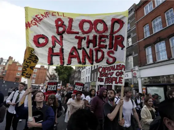  ??  ?? Protesters make their way from Kensington Town Hall to the site of the tower near Notting Hill (AP)