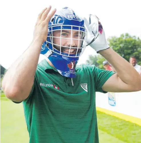  ?? NATHAN DENETTE / THE CANADIAN PRESS ?? Canadian Adam Hadwin puts on a goaltender’s mask that was used as the tee block on the seventh hole during Wednesday’s pro-am ahead of this week’s Canadian Open at the Glen Abbey Golf Club in Oakville.