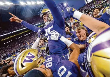  ?? Dean Rutz/Seattle Times ?? Washington teammates carry Grady Gross off the field after he kicked the winning field goal against Washington State on Saturday in Seattle to cap the Huskies’ perfect regular season.