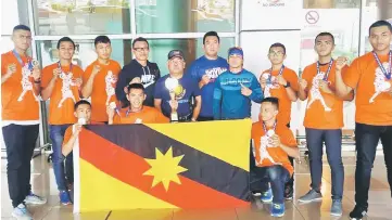  ??  ?? Rahman (fifth left) with (from fourth right) Wilbur, Helman, Fred and the state boxers upon arrival at the Kuching Internatio­nal Airport.