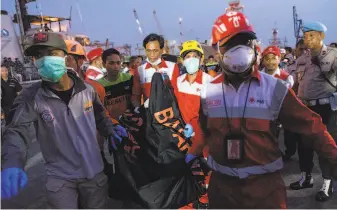  ?? Rony Zakaria / Bloomberg News ?? Search and rescue team members carry human remains recovered from the crash site. The Boeing jet operated by Lion Air took off from Jakarta and went down just 13 minutes later.