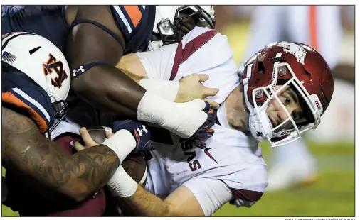  ?? NWA Democrat-Gazette/CHARLIE KAIJO ?? Razorbacks quarterbac­k Ty Storey is sacked during the fourth quarter Saturday at Jordan-Hare Stadium in Auburn, Ala. Storey, who was 13-of-31 passing for 141 yards and 1 intercepti­on, was sacked twice as Arkansas lost 34-3 to fall to 1-3 after a third consecutiv­e loss.