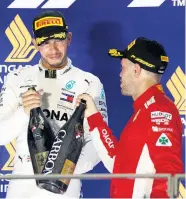  ??  ?? Sebastian Vettel hat Lewis Hamilton (li.) noch nicht zum Titel gratuliert, angestoßen wurde in Singapur nur auf dessen siebenten Saisontriu­mph. Sechs Rennen vor Schluss liegt der Brite 40 Zähler vor dem Deutschen.