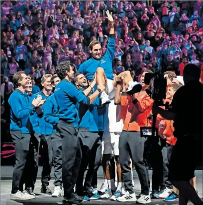  ?? ?? Los componente­s de los equipos de Europa y del Mundo en la Laver Cup mantean a un eufórico Federer.