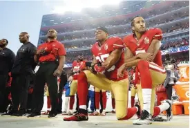  ?? ASSOCIATED PRESS FILE PHOTO ?? San Francisco 49ers safety Eric Reid, right, and quarterbac­k Colin Kaepernick kneel during the national anthem before a game on Sept, 12, 2016.