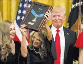  ?? Andrew Harnik ?? The Associated Press Valerie Nessel, second from left, accepts the Medal of Honor on Wednesday from President Donald Trump on behalf of her husband, Air Force Tech. Sgt. John A. Chapman, who was posthumous­ly honored.