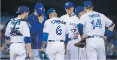  ?? NATHAN DENETTE/THE CANADIAN PRESS ?? Blue Jays pitching coach Pete Walker, second left, speaks with starting pitcher Marcus Stroman.