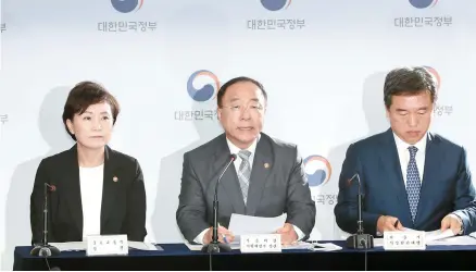  ?? Yonhap ?? Deputy Prime Minister and Finance Minister Hong Nam-ki, center, Land Minister Kim Hyun-mee, left, and acting Seoul Mayor Seo Jeong-hyub give a press briefing at the Seoul Government Complex in Gwanghwamu­n, Tuesday.