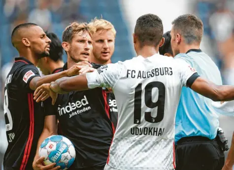  ?? Foto: dpa ?? Beim Auswärtssp­iel des FC Augsburg in dieser Saison in Frankfurt waren einige Eintracht‰Spieler nicht mit der Leistung von Schiedsric­hter Harm Osmers zufrieden. Augs‰ burgs Felix Uduokhai versucht in dieser Szene zu schlichten.