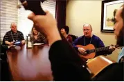  ?? CHRIS SWEDA / CHICAGO TRIBUNE ?? Doug Brown (second from right), a resident of Silverado Memory Care near Chicago, plays the guitar during a music therapy program earlier this year for people with dementia and Alzheimer’s disease. A new study links viruses to Alzheimer’s.