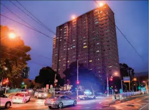  ?? (AFP) ?? Police vehicles park outside one of nine public housing estates which have been locked down in Melbourne on Saturday.