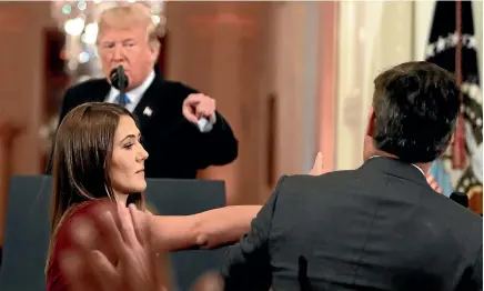  ?? AP ?? CNN’S Jim Acosta leans away as a White House aide tries to take the microphone from him during a news conference in the East Room of the White House.