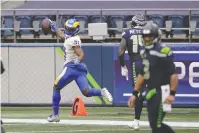  ?? The Associated Press ?? Los Angeles Rams defensive back Darious Williams (31) looks back as he scores on an intercepti­on from Seattle Seahawks quarterbac­k Russell Wilson, right, during the first half of Saturday’s wild-card playoff game in Seattle.