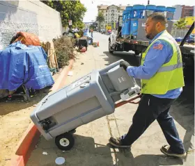  ?? Eduardo Contreras / Associated Press ?? Edwin Gonzalez of United Site Services delivers a two-station hand washing sink in downtown San Diego.