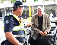  ??  ?? Pell is assisted by an Australian policeman as he gets out of a car upon arriving at the Melbourne Magistrate­s’ Court in Australia in this file photo. — Reuters photo