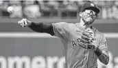  ?? Ed Zurga / Getty Images ?? Shortstop Carlos Correa throws to first to get out Whit Merrifield during the third inning.