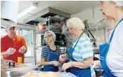  ?? LESLIE OVALLE/STAFF PHOTOGRAPH­ER ?? From left, Bob Reid, Justin Mueller, Norma Lewis and Marie Salanitri prepare to serve dinner on The Holy Grill.