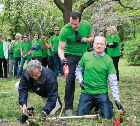  ??  ?? TreadRight Foundation founder Brett Tollman, right, plants an ivy plant in El Retiro Park, Madrid, to enhance the landscape as part of a volunteer effort.