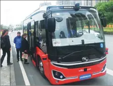  ?? WANG QUANCHAO / XINHUA ?? Passengers board an autonomous bus in Chongqing.
