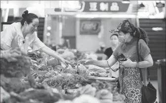  ?? SU YANG / FOR CHINA DAILY ?? A shopper buys vegetables at a market in Nanjing, Jiangsu province.