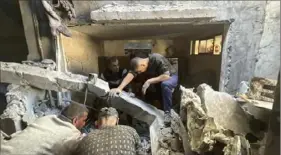  ?? Courtesy of Maha Abu Kuwaik via AP ?? Rescuers look for signs of life in the rubble of a home destroyed by an Israeli airstrike on Dec. 6, in Nuseirat refugee camp in the Gaza Strip.