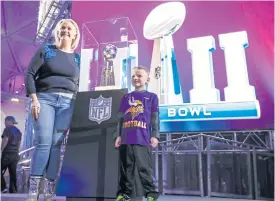  ??  ?? Fans pose with the Vince Lombardi trophy in Minneapoli­s.