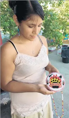  ?? William Yardley
Los Angeles Times ?? WINONA RAMOS, who manages the donations, holds a beaded medallion she made for her boyfriend, who is out fighting a nearby wildfire.