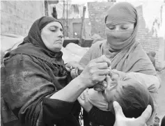  ??  ?? A Pakistani health worker administer­s polio vaccine drops to a child during a polio campaign in Lahore in this file photo.— AFP photo